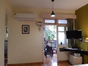 a living room with a door leading to a dining room at Palm Grove 1 Bhk Apartment at Candolim Beach with free Wifi in Candolim