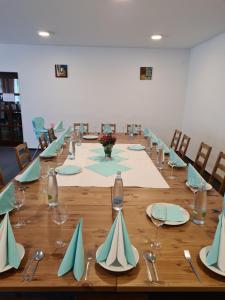 a long wooden table with chairs and plates and napkins at Wellness hotel Harrachovka in Harrachov
