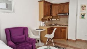 uma sala de estar com uma cadeira roxa e uma cozinha em Vlašićka idila apartman Eko Fis 507 em Vlasic