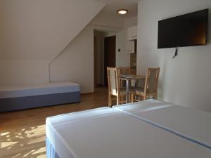 a room with a bed and a table and chairs at Willa Halusia in Zakopane