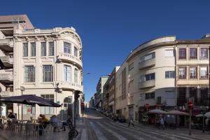 een stadsstraat met gebouwen en mensen aan tafel bij Tripas-Coração, Santa Catarina in Porto