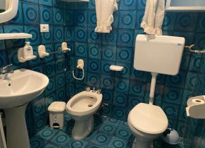 Baño de azulejos azules con aseo y lavamanos en Villa conchilglia - 30 metri dal mare en Lido Conchiglia