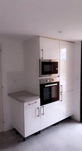 a white kitchen with a stove and a microwave at RDC Villa - Résidentiel - Entrée indépendante in Marseille