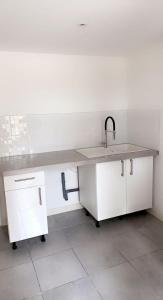 a white kitchen with a sink and a counter at RDC Villa - Résidentiel - Entrée indépendante in Marseille
