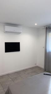 a white room with a flat screen tv on a wall at RDC Villa - Résidentiel - Entrée indépendante in Marseille