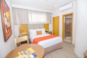 a bedroom with a bed and a desk at Hotel American Golf in Barranquilla