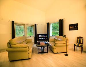 ein Wohnzimmer mit 2 Sofas und einem Tisch in der Unterkunft Granbackens BoB in Falun