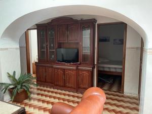 a living room with a entertainment center with a television at Fuseta Holiday House in Fuzeta