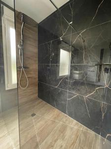 a bathroom with a shower and a black wall at Escapade de Vauclair in Bouconville-Vauclair