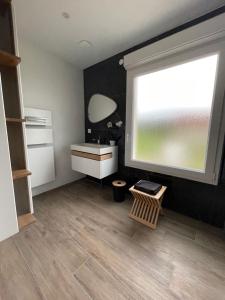 een kamer met een raam, een bureau en een wastafel bij Escapade de Vauclair in Bouconville-Vauclair