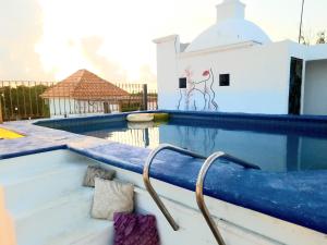 une piscine avec une rampe à côté d'un bâtiment dans l'établissement Casa Quintal - Cerca del mar, à Cancún