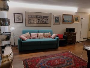 sala de estar con sofá azul y alfombra en Verona City San Zeno Apartment, en Verona