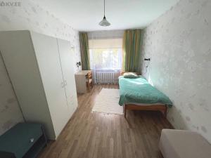 a small room with a bed in a room with a window at Samanta Apartaments in Sillamäe