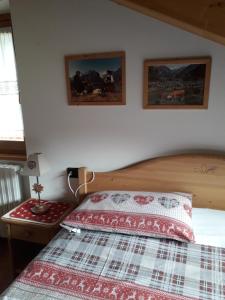 a bedroom with a bed and two pictures on the wall at Casa Vacanze Michela in Santa Caterina Valfurva