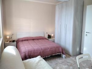 a bedroom with a bed with a pink bedspread at la casa all 'angolo in Pisa
