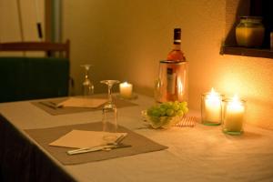 a table with a bottle of wine and grapes and candles at Bungalovy Natura in Trávnica +21 photos