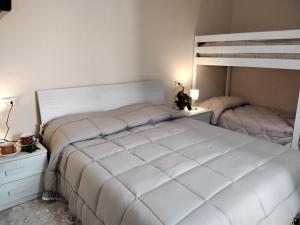 a bedroom with a white bed and a bunk bed at la casa all 'angolo in Pisa