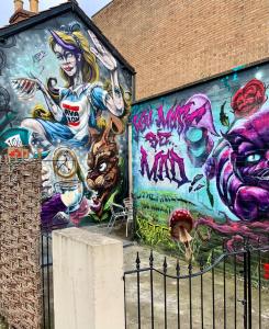 un edificio con un muro coperto di graffiti di The Rabbit Hole a Glastonbury