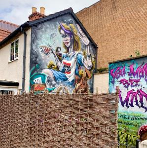 une fresque d'une femme sur le côté d'un bâtiment dans l'établissement The Rabbit Hole, à Glastonbury