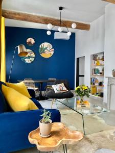 a living room with a blue wall and a blue couch at Grand confort au cœur de Nîmes in Nîmes