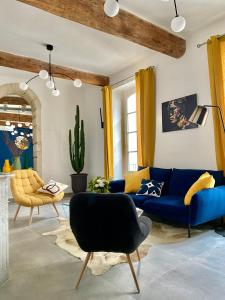 ein Wohnzimmer mit einem blauen Sofa und einem Stuhl in der Unterkunft Grand confort au cœur de Nîmes in Nîmes