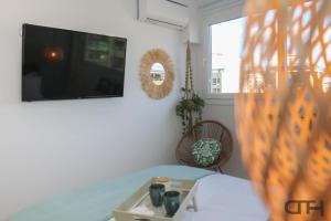 a living room with a table and a flat screen tv at New deluxe studio 2 downtown Thessaloniki-Fully equiped in Thessaloniki