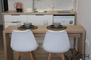 a kitchen with a wooden table and two white chairs at New deluxe studio 2 downtown Thessaloniki-Fully equiped in Thessaloniki