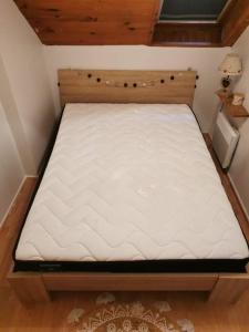 a bed in a small room with a white mattress at Le petit Chalet Luchonnais in Luchon