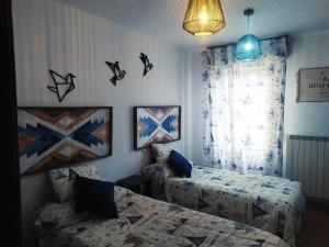 1 dormitorio con 2 camas y una ventana con pájaros en la pared en Wood, Wine & Golf, en Sojuela
