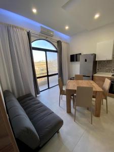 a living room with a couch and a dining room table at Diamonds Luxury apartment - Julia in Marsalforn