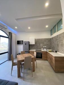 a kitchen with a wooden table and chairs and a kitchen with a counter at Diamonds Luxury apartment - Julia in Marsalforn
