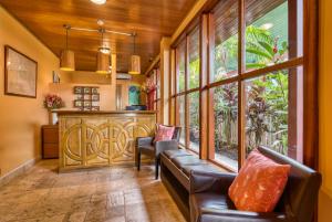 a living room with leather chairs and a large window at Hotel Palma Royale in Bocas Town