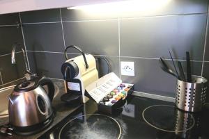 a kitchen counter with a coffee maker and a tea kettle at 7 min Walk Metro Line 1-La Defense Charras in Courbevoie