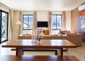 Marine Square Luxury Suites في هيرمانوس: غرفة معيشة مع طاولة وأريكة