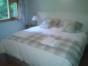 a bedroom with a large bed with towels on it at Manor Garden Lodge in Wirral