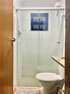 y baño con ducha y aseo. en Vila Lorenzi - Apartamentos, en Ubatuba