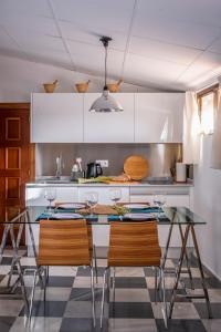 uma cozinha com uma mesa de vidro e cadeiras em attic 27 em Villanueva de los Infantes