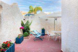 a patio with a table and chairs and flowers at La Maiolica in Noto Marina