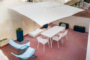 a table and chairs with an umbrella on a patio at La Maiolica in Noto Marina