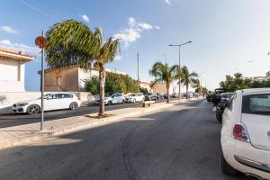 a street with cars parked on the side of the road at La Maiolica in Noto Marina