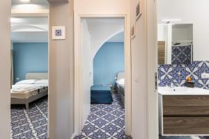 a bathroom with a sink and a bedroom with a bed at La Maiolica in Noto Marina