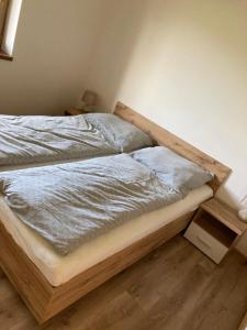 uma cama com uma estrutura de madeira num quarto em Donovaly Panoráma 26 em Donovaly