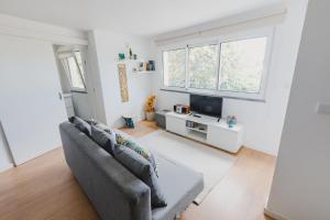 Una sala de estar con un sofá y un televisor. en O Clube, en Porto da Cruz