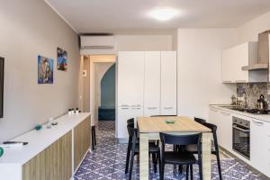 a kitchen with white cabinets and a table and chairs at La Maiolica in Noto Marina