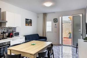 a kitchen and dining room with a table in a room at La Maiolica in Noto Marina
