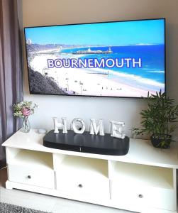 un televisor sentado en la parte superior de un puesto de TV blanco en Modern House in Bournemouth town centre, en Bournemouth