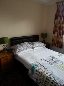 a bed in a bedroom with two lamps on a night stand at Ocean's in Dawlish