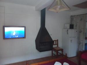 Een TV en/of entertainmentcenter bij Bungalows Atardecer Apart Hotel
