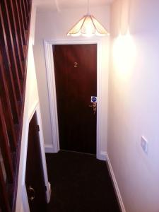 um corredor com uma porta preta e uma luz em Ocean's em Dawlish