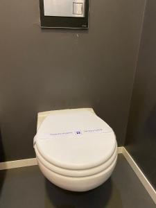 a white toilet in a bathroom with a wall at APPARTALOFT CENTRALE VR48 in Turin